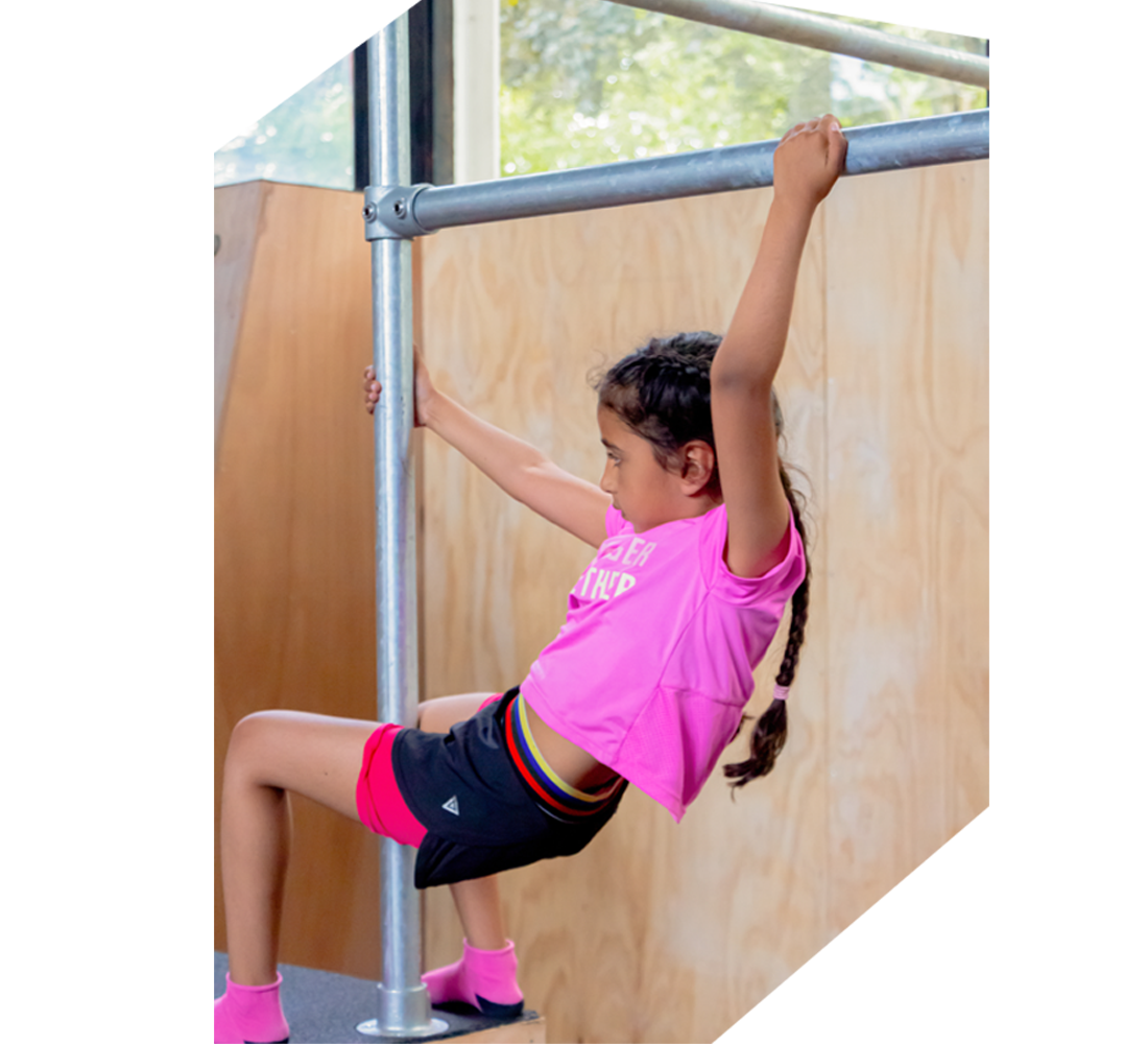 Meisje klimt op bar bij Freerunworkshop en clinic